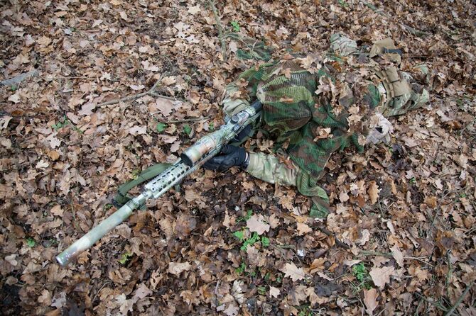 森の地面に隠れる狙撃兵