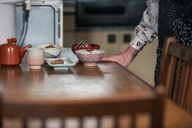 孤独に食べる年配の日本人女性