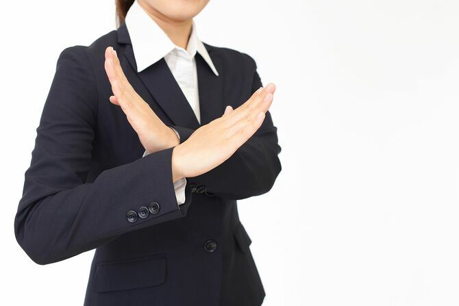 クロスハンドでストップサインをする女性