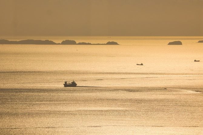 夕暮れ時の黄金の海と漁船