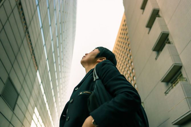 ビルの谷間で上を見上げる女性