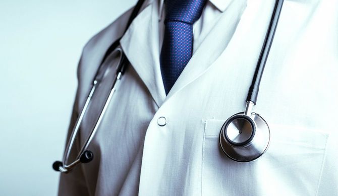 聴診器を首から下げ、白衣を着ている医師
