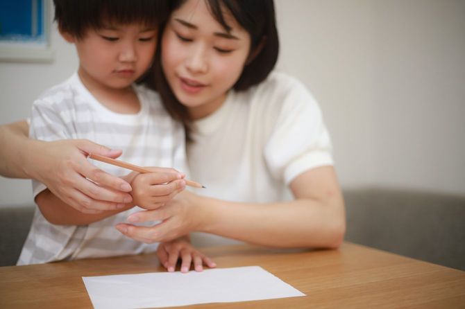 鉛筆の持ち方を練習する親子