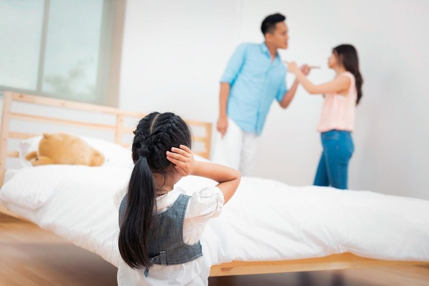 子どもの前で喧嘩をする夫婦と耳をふさぐ子ども