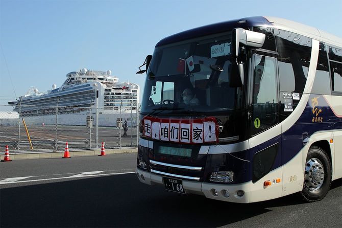 クルーズ船「ダイヤモンド・プリンセス」から下船した乗客を運ぶバス。日本と中国の国旗が掲げられていた