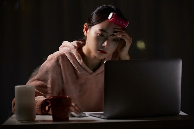 夜中に自宅で働く若いアジア人女性