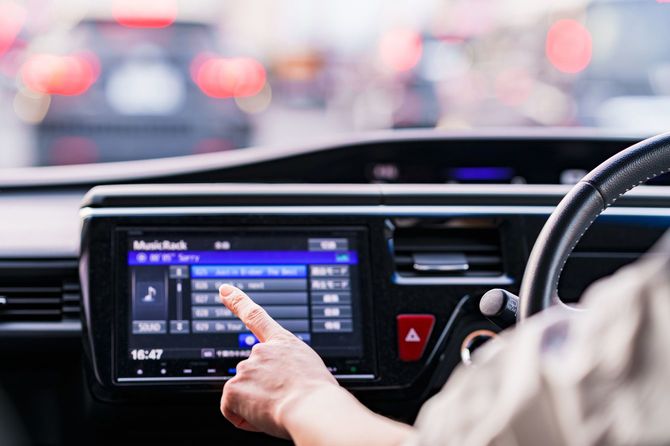 信号待ちの間に音楽を変えようとしている人の手元