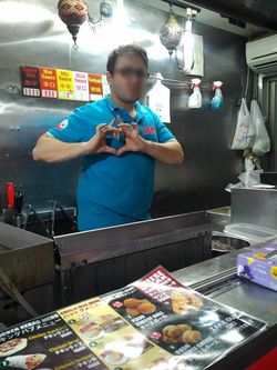 スマホを向けるとノリノリでポーズしてくれたフレンドリーなチーズボール店のスタッフ