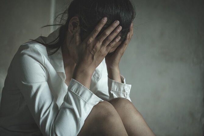 顔を覆う若い女性