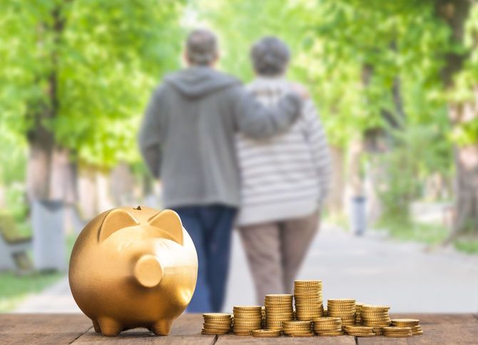 肩を組んで歩くシニアカップルと金の豚の貯金箱
