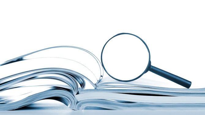開いて置かれた資料の上に拡大鏡
