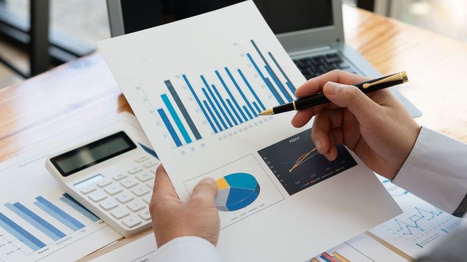 オフィスでレポートのグラフを分析するビジネスマン