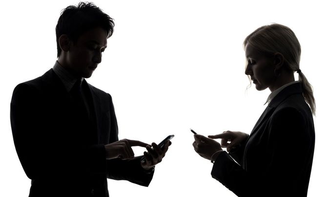 向き合ってスマホを使用する男女