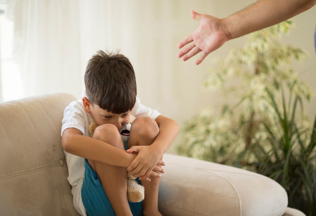 親にしかられて縮こまっている男児