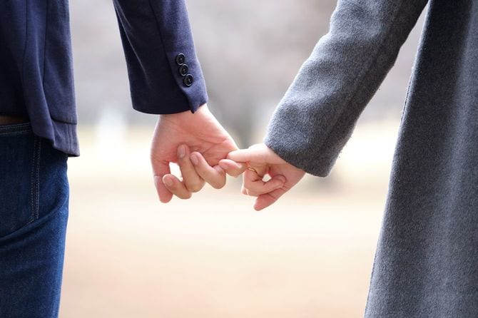 冬の公園で手をつないでいる日本人男女