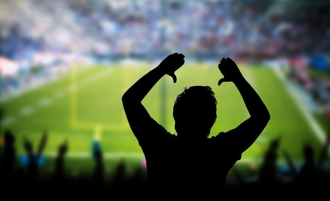 スポーツイベントで興奮して腕を上げる男