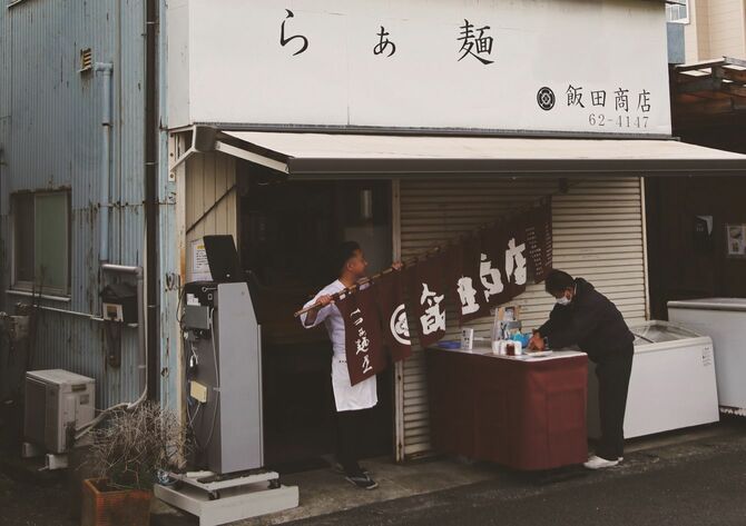 「飯田商店」の開店は11時。暖簾を出すのは店主・飯田将太さんの仕事。