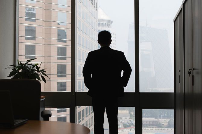 ビジネスの男性の窓を通して