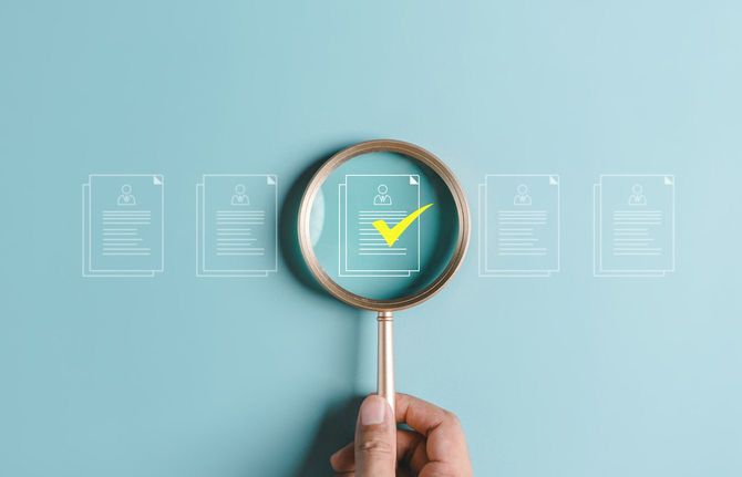 ルーペで履歴書を見る手