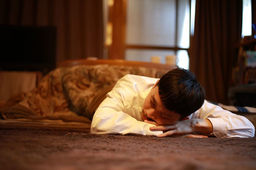 こたつで寝ている男性