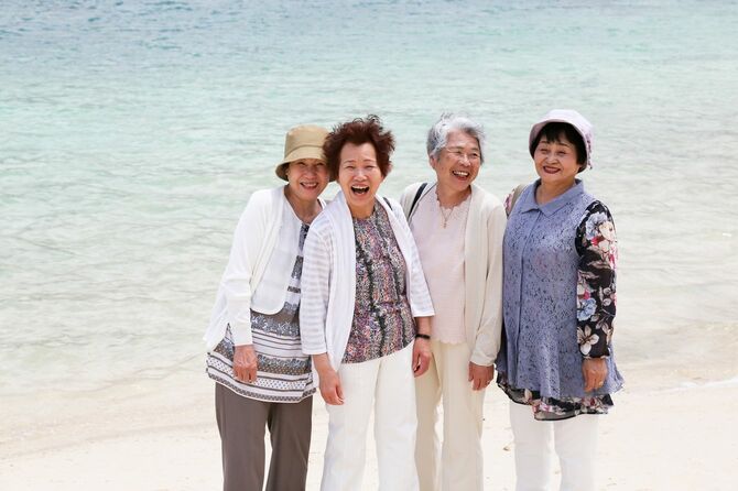 ビーチで笑いがはじけるシニア女性のグループ