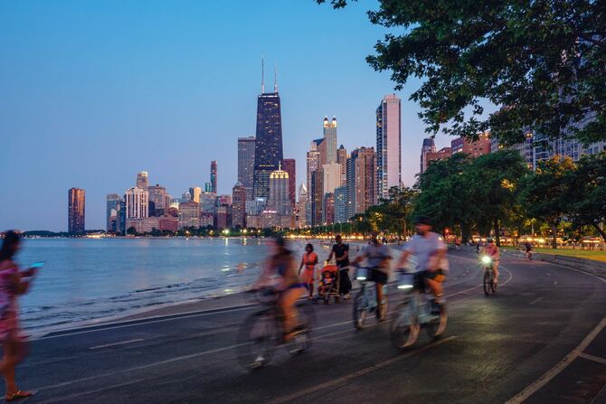 シカゴのスカイラインを背景に、夜に自転車に乗る人々