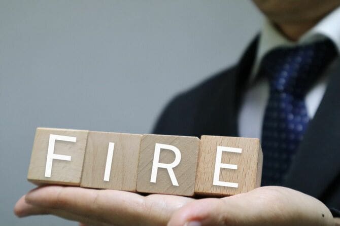 FIREと書かれた木製ブロックを持つ人