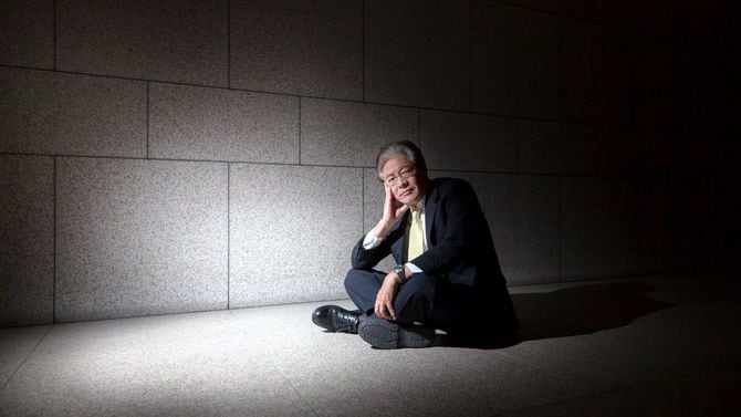 深刻そうな表情で座り込むビジネスパーソン