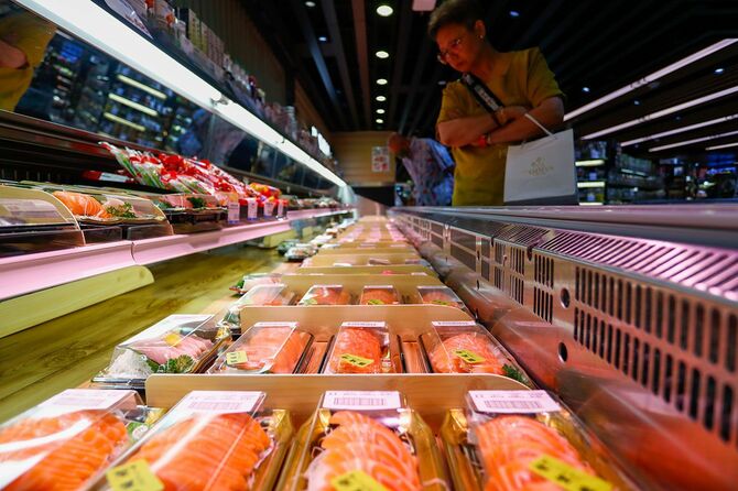 輸入禁止措置の対象となった日本の魚介類を扱うスーパーで、寿司や刺身を見ている客＝2023年8月23日、香港