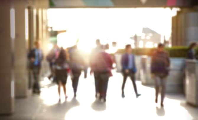 街を歩くビジネスマンが、光の反射でぼやけているイメージ。