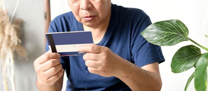 銀行口座通帳を見て驚く男性