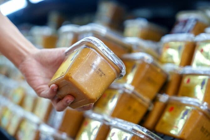 スーパーで味噌を選ぶ人の手元