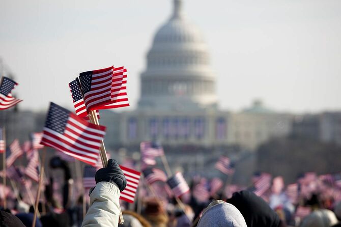 ワシントンD.C.の国会議事堂前で星条旗を振る人々
