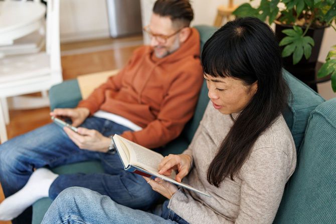 ソファで本を読んだりしてくつろぐカップル