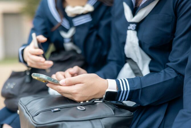 スマートフォンを使う女子高生