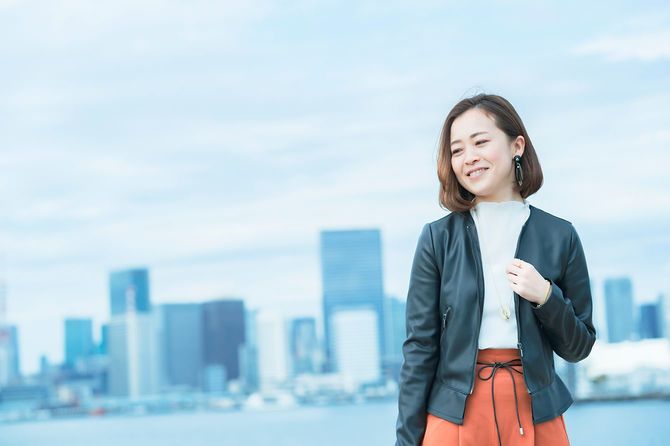 オフィスカジュアルスタイルの女性が微笑む