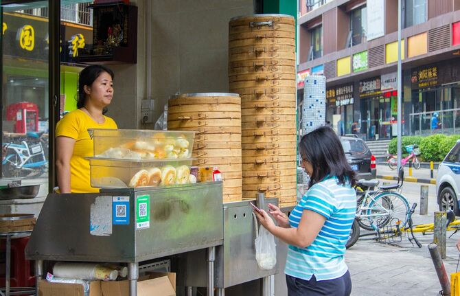 2018年11月14日、中国・深圳の露店で朝食を購入する女性はQRコード決済している