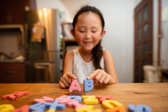 アルファベットの模型で勉強する女の子