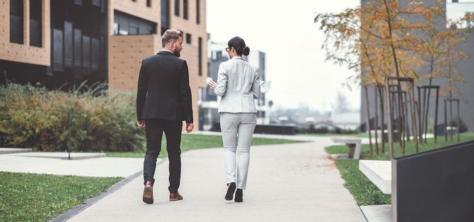 話しながら歩く2人のビジネスパーソン