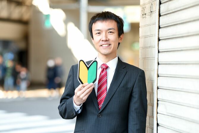 初心者マークを手に、ほほ笑む男性