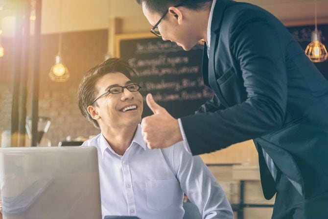 サムズアップで相手を称える男性