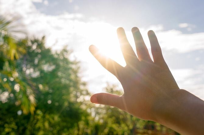 太陽の光を遮る手