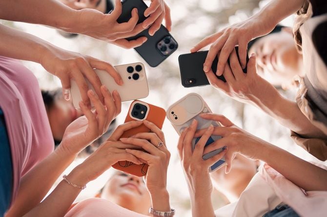 おのおのがスマホを手にぐるっと輪になっているグループ