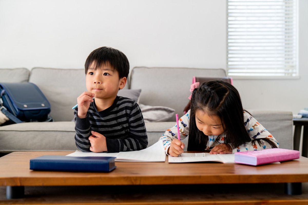 家で宿題をしている二人の子ども