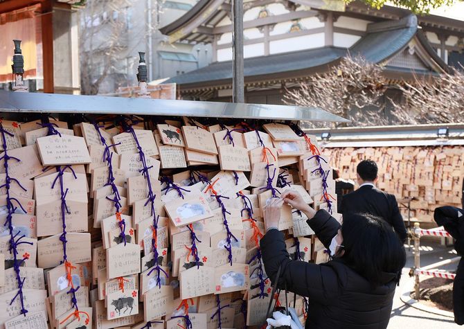 大学入学共通テストなどの受験シーズンを前に、学問の神様・菅原道真を祭る湯島天神（東京都文京区）では、合格祈願のため絵馬を奉納する人たちの姿が見られた＝2023年1月11日