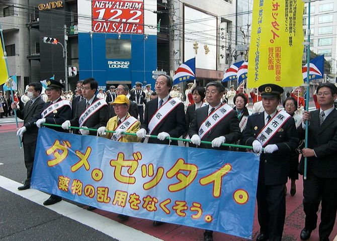 「ダメ。ゼッタイ。」の横断幕を持って歩く区長ら