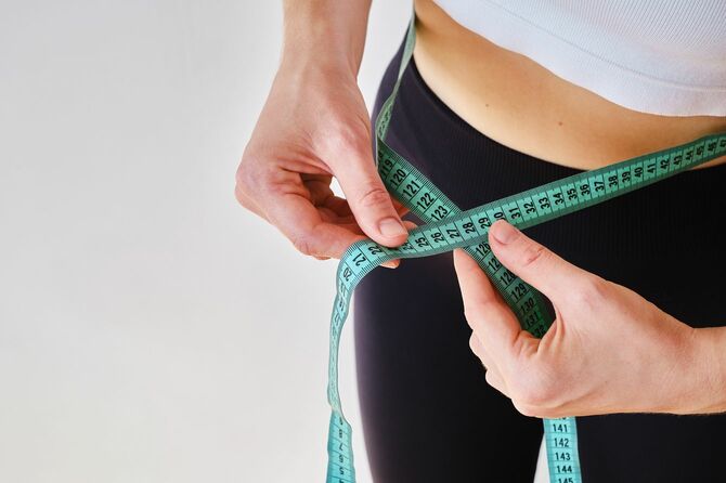 細い腰に巻尺を持っている人