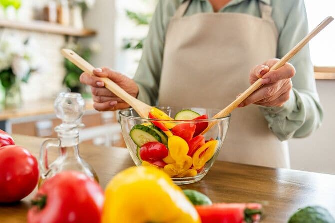 ボウルの野菜を混ぜる主婦
