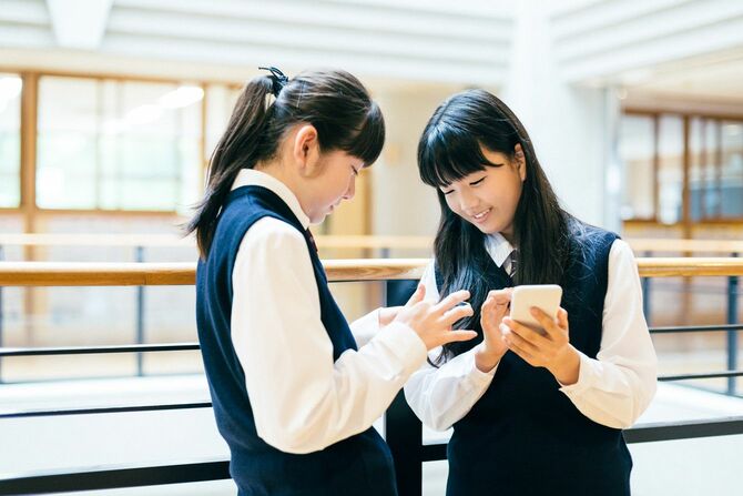 学校でスマートフォンを使う日本の女子高生