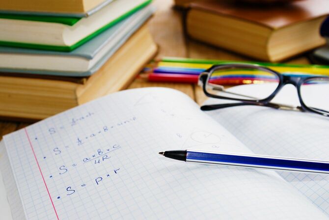 机の上のノートとペン、眼鏡